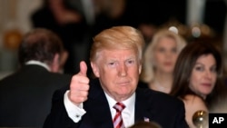 President Donald Trump gives a thumbs-up as he has Thanksgiving Day dinner at his Mar-a-Lago estate in Palm Beach, Fla., Thursday, Nov. 22, 2018. 