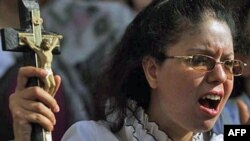 Một phụ nữ Cơ Ðốc giáo Coptic biểu tình trước một đài truyền hình ở Cairo, phản đối các vụ tấn công nhắm vào tín đồ Cơ Ðốc giáo và nhà thờ