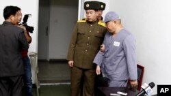 American missionary Kenneth Bae (R) leaves after speaking to reporters at Pyongyang Friendship Hospital in Pyongyang, Jan. 20, 2014.