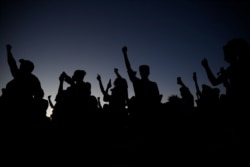 FILE - Protesters hold their fists in the air during a rally June 5, 2020, in Las Vegas, sparked by the death of George Floyd, a black man who died after being restrained by Minneapolis police officers on May 25.