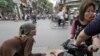 FILE - An older Vietnamese woman begs for money on a busy Hanoi street.