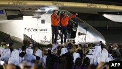 Bertrand Piccard (R) and Andre Borschberg (L), pilots of the solar powered Solar Impulse 2 aircraft, are greeted upon arrival at Al Batin Airport in Abu Dabi to complete its world tour flight on July 26, 2016, in the United Arab Emirates.