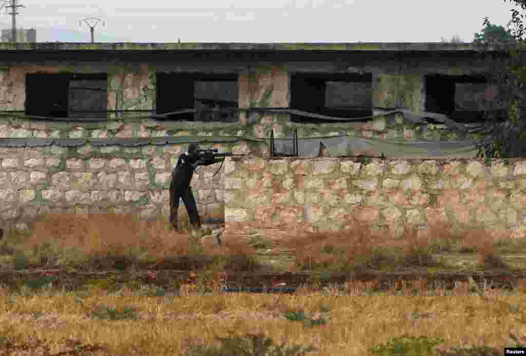 A member of the Free Syrian Army stands guard during a shelling by pro-government forces on the outskirts of Atareb, in Idlib governorate, Syria, October 24, 2012.