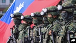 FILE - Soldiers pose for group photos with a Taiwanese flag after a preparedness enhancement drill simulating the defense against Beijing's military intrusions, ahead of the Lunar New Year in Kaohsiung City, Taiwan, on Jan. 11, 2023.