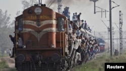FILE - Passengers travel on an overcrowded train at Loni town in the northern Indian state of Uttar Pradesh.
