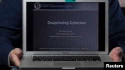 FILE - A cyber warfare expert who is chief technology officer of the U.S. Cyber Consequences Unit, a non-profit group that studies the impact of cyber threats, holds a notebook computer while posing for a portrait.