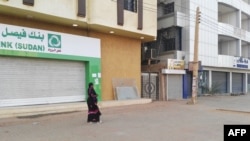 A woman walks past two closed banks in a deserted street in Sudan's capital Khartoum, Sudan, June 4, 2019.