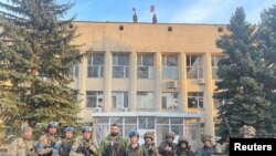 Ukrainian troops pose for a photo in Lyman