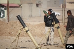 An Iraqi soldier loads a mortar to fire into IS-held areas on the outskirts of Mosul, Iraq, Nov. 23, 2016. (H. Murdock/VOA)
