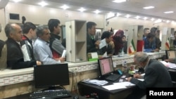 FILE - Afghans wait in line at the Soleimankhani center for refugees in Tehran, Iran, Oct. 24, 2016.