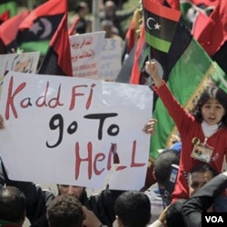 Warga di Benghazi melakukan unjuk rasa dengan membawa berbagai poster anti-Gaddafi.