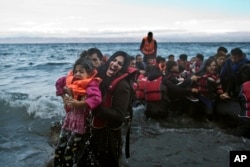 A woman screams for help after she and her daughter fell in the water as they arrive along the northeastern Greek island of Lesbos, Oct. 2 , 2015.