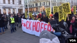 Angry demonstrators, carrying a banner with obscene language, march in protest against far-right presidential candidate Norbert Hofer in Vienna, Dec. 3, 2016. (L. Ramirez/VOA)