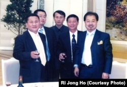 Ri Jong Ho, left, poses with Chinese investment tycoon Sam Pa, right, and others at a banquet hall in Pyongyang in January 2007.