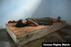 A 24-year-old female resident lies with her wrist and ankle chained to a platform bed at Bina Lestari healing center in Brebes, Central Java. © 2012 Andrea Star Reese for Human Rights Watch