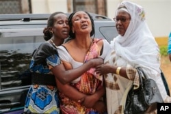 Relatives and friends grieve during the funeral of Patrick Ndikumana, Friday, July 3, 2015, in Bujumbura, Burundi. According to relatives Ndikumana was killed in the police attack in Jabe neighborhood last week. A U.N. observer mission concluded Thursday