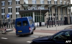 FILE - United Nations inspectors arrive in a van at the headquarters of the Organization for the Prohibition of Chemical Weapons (OPCW), in The Hague, Aug. 31, 2013.