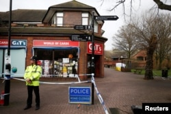 A police officer stands at a cordon around the bench where former Russian intelligence agent Sergei Skripal and his daughter Yulia were found after they were poisoned, in Salisbury, Britain, March 11, 2018.