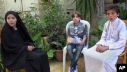 FILE - This undated frame grab from video provided by Bashar Sakka, producer of the sit-com, “Um Abdou the Aleppan,” shows Syrian actor Qusai Abtini, right, while filming an episode with Rasha, left, known as Umm Abdou, in Aleppo, Syria.