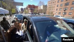 Members of the U.S. Army National Guard distribute boxes of free food provided by multiple New York City agencies, during the outbreak of the coronavirus disease in the Harlem neighborhood of Manhattan in New York City, April 15, 2020. 