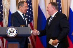 Secretary of State Mike Pompeo, right, shake hands with Russian Foreign Minister Sergey Lavrov, after a media availability at the State Department in Washington, Dec. 10, 2019.