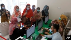 Heath workers register woman before they can be vaccinated with the Sinovac COVID-19 vaccine at a vaccination center, in Lahore, Pakistan, June 3, 2021.