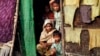 A Burmese Muslim family, who identify themselves as long-persecuted “Rohingya” Muslims, look out from their tents at Da Paing camp for Muslim refugees in north of Sittwe, Rakhine State, western Burma, April 2, 2014. 