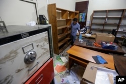 An employee walks through a ransacked office of the nongovernmental organization Popol Na Foundation, in Managua, Nicaragua, Dec. 14, 2018. Nicaraguan police raided the offices of five nongovernmental organizations and Confidencial on Thursday, alleging that they participated in seeking the government's overthrow.