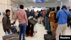 FILE - Egyptian men wait to board their plane to return home, at the Gabes Matmata airport, south of Tunisia Aug. 6, 2014.