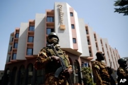 Tight security surrounds Malian President Ibrahim Boubacar Keita as he visits the Radisson Blu hotel in Bamako, Mali, Nov. 21, 2015.