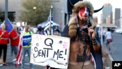 FILE - Jacob Anthony Chansley, who also goes by the name Jake Angeli, a QAnon follower, speaks to supporters of then-President Donald Trump outside of the Maricopa County Recorder's Office, in Phoenix, Nov. 5, 2020.