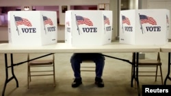 A voter casts a ballot at the Flushing Volunteer Fire Department in Flushing, Ohio, March 6, 2012. 