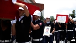 FILE - Turkish police officers carry the coffin of slain police officers Serdar Kazar and Isa Ipek, killed in an attack by Kurdish rebels overnight, in the the city of Adana, southern Turkey, July 31, 2015.