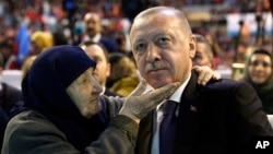Turkey's President Recep Tayyip Erdogan with a supporter of his ruling Justice and Development Party, AKP, during a meeting with women in Sanliurfa, Turkey, March 8, 2019, ahead of local elections scheduled for March 31, 2019. 