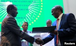 Field Marshal of the Ethiopian National Defence Force Birhanu Jula and Tadesse Werede Tesfay of the Tigray forces shake hands during the signing of the implementation of the cessation of hostilities, in Nairobi, Kenya, Nov. 12, 2022.