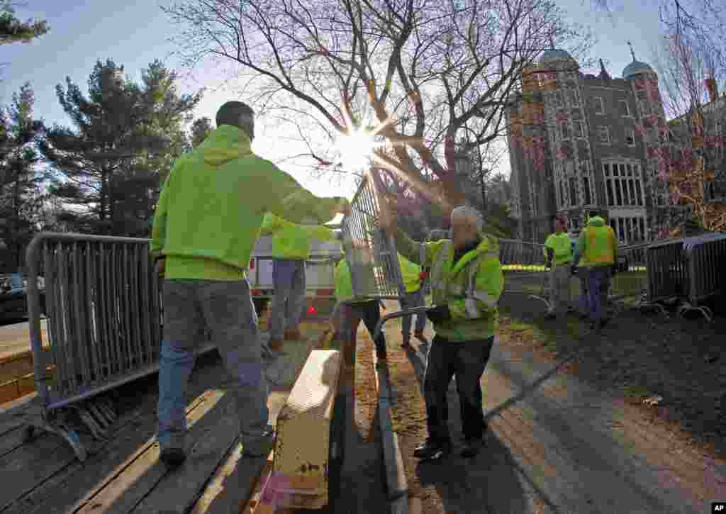 Para petugas memasang pagar keamanan di depan Wellesley College di pagi hari sebelum Boston Marathon ke-118 dimulai, di Wellesley, Mass., 21 April 2014.