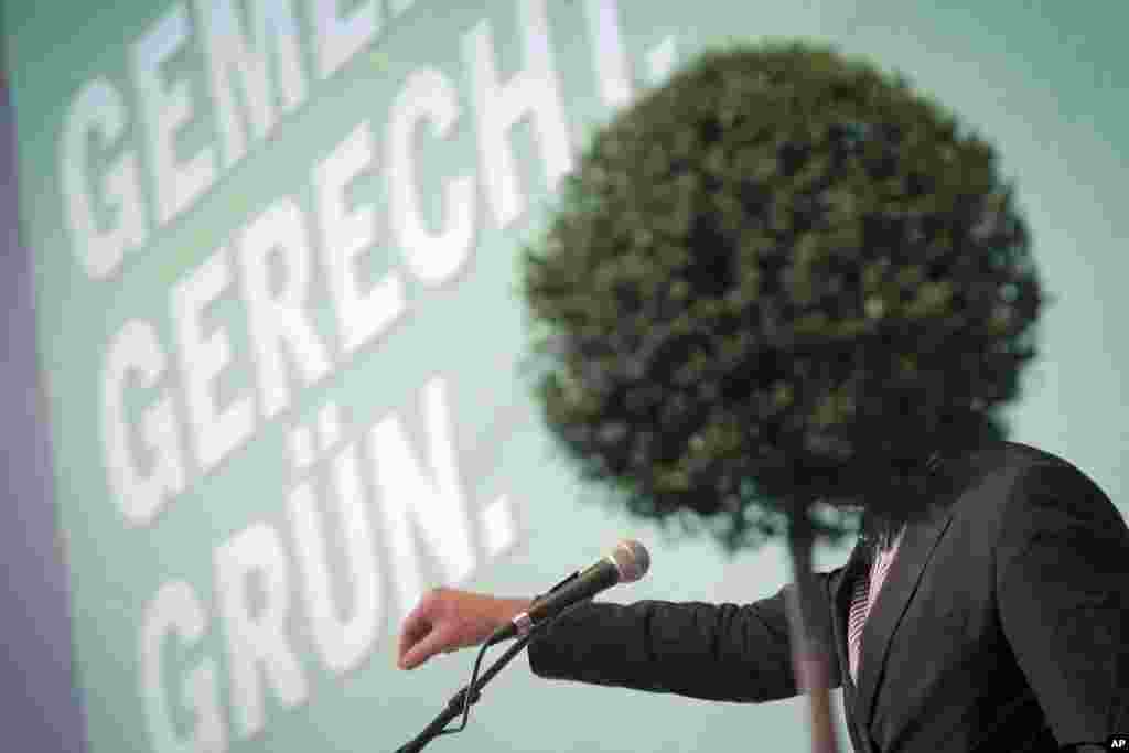 Wajah calon utama dari Partai Hijau dalam pemilu Jerman mendatang,Juergen Trittin, terhalang tanaman ketika ia berpidato dalam konvensi partai di Bingen, Jerman barat.