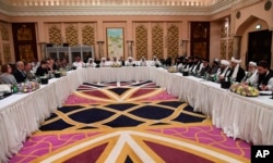 FILE - This photo released by Qatar's Ministry of Foreign Affairs shows Qatari, U.S. and Taliban officials conferring in an undisclosed place in Doha, Feb. 25, 2019, ahead of the latest round of talks with the insurgents aimed at ending the Afghan war.