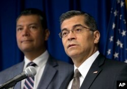 FILE - California Attorney General Xavier Becerra, right, flanked by Secretary of State Alex Padilla, speaks to reporters at the Capitol in Sacramento, Sept. 5, 2017.