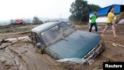 Une voiture bloquée dans la boue après que de fortes pluies ont frappé Fushun, dans la province du Liaoning, en Chine, le 17 août 2013. 