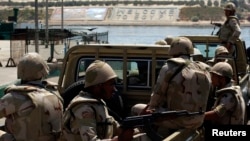 Egypt's army troops cross the Suez Canal to work on an upgrading project to guard Ismailia, a port city northeast of Cairo, Aug. 12, 2014. 