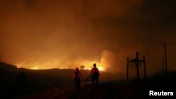 Dua pemadam kebakaran memantau kebakaran Kincade dekat Geyserville, California, Kamis, 24 Oktober 2019.