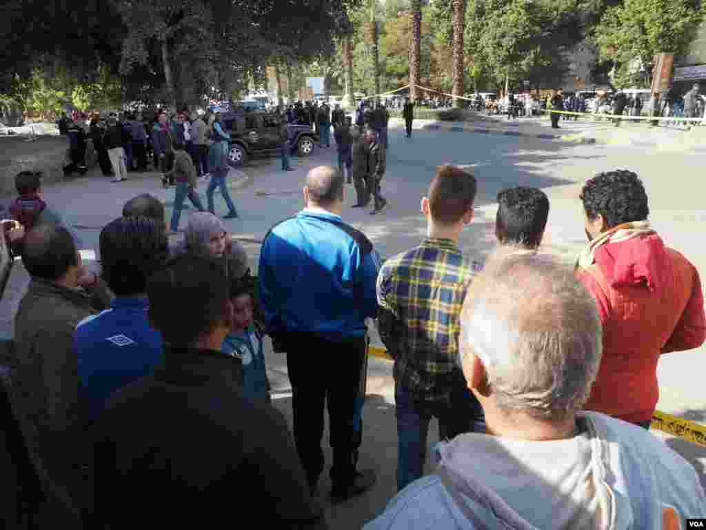 Residents watch the inspection of the explosion in Giza, Egypt, Dec. 9, 2016. The explosion hit at 9:30 a.m., and then police blocked the road. (H. Elrasam/VOA)