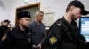 Founder of the Baring Vostok investment fund Michael Calvey, center, is escorted to the courtroom in Moscow, Feb. 15, 2019. A veteran U.S. investment fund manager has been detained in Moscow and faces fraud charges.