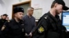 Founder of the Baring Vostok investment fund Michael Calvey, center, is escorted to the courtroom in Moscow, Feb. 15, 2019. A veteran U.S. investment fund manager has been detained in Moscow and faces fraud charges.