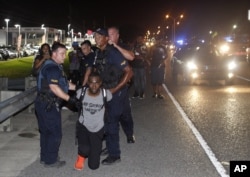 FILE - Police arrest Black Lives Matter leader Deray McKesson during a protest along Airline Highway, a major road that passes in front of the Baton Rouge Police Department headquarters, July 9, 2016.
