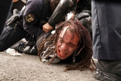 Louisville police detain a man after a group marched, Sept. 23, 2020, in Louisville, Ky. A grand jury has indicted one officer on criminal charges six months after Breonna Taylor was fatally shot by police in Kentucky.