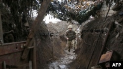 A Ukrainian serviceman walks along a trench at a position on the frontline with Russia-backed separatists near Gorlivka, Donetsk region, April 14, 2021. 