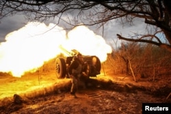 Ukrainian service members fire a howitzer D30 at a front line near the city of Bakhmut.