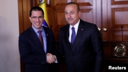 Menlu Venezuela Jorge Arreaza bersama Menlu Turki Mevlut Cavusoglu (kanan) di Ankara, Turki, 1 April 2019.